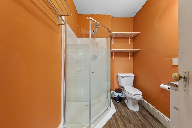 300 Ellington St, West Concord, MN 55985 - bathroom featuring toilet, wood finished floors, a stall shower, and baseboards