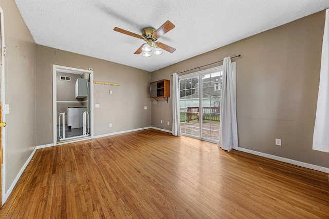 300 Ellington St, West Concord, MN 55985 - empty room with wood finished floors, a ceiling fan, baseboards, and a textured ceiling