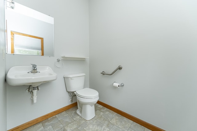 520 State St, West Concord, MN 55985 - bathroom featuring toilet, baseboards, and a sink