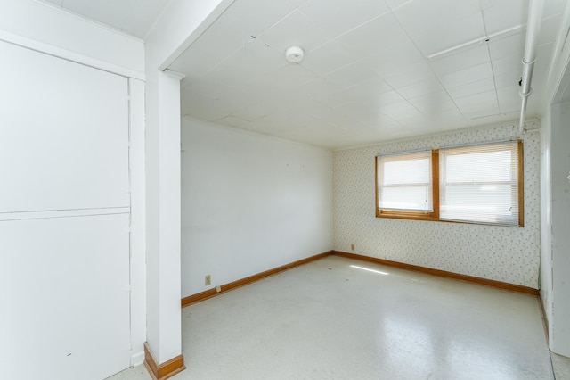 520 State St, West Concord, MN 55985 - empty room featuring baseboards, wallpapered walls, and a smoke detector