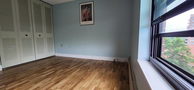 6615 Lake Shore Dr S Unit 717, Richfield, MN 55423 - unfurnished bedroom featuring wood finished floors and a closet