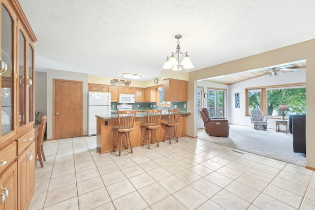 1852 13th Ave W, Shakopee, MN 55379 - kitchen with white appliances, light tile patterned floors, open floor plan, a peninsula, and a chandelier