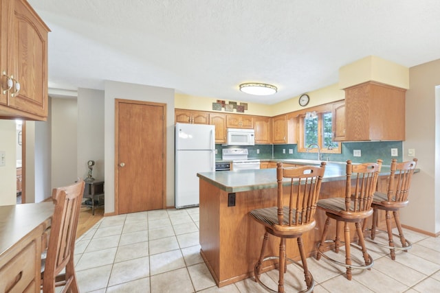 1852 13th Ave W, Shakopee, MN 55379 - kitchen with white appliances, a peninsula, light tile patterned floors, decorative backsplash, and a breakfast bar