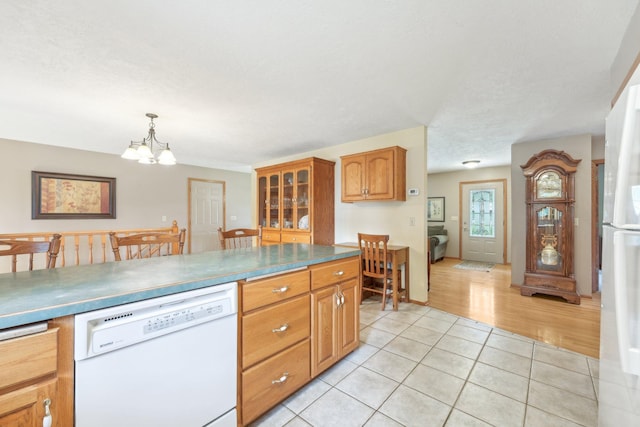 1852 13th Ave W, Shakopee, MN 55379 - kitchen featuring dishwasher, a chandelier, light tile patterned floors, brown cabinets, and glass insert cabinets