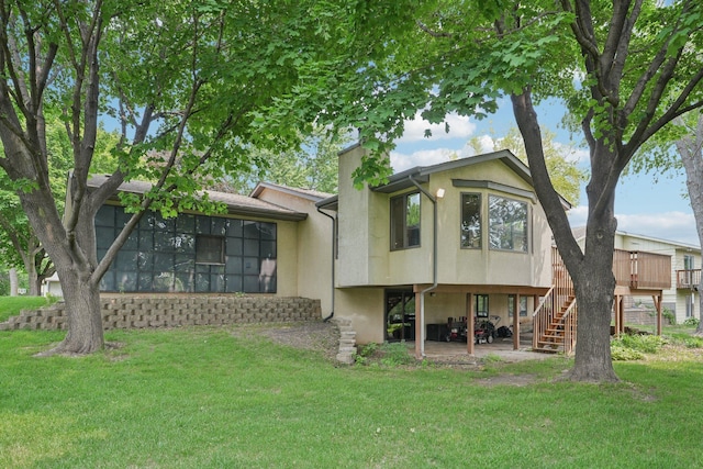 1852 13th Ave W, Shakopee, MN 55379 - rear view of house with a chimney, stucco siding, a lawn, stairs, and a deck