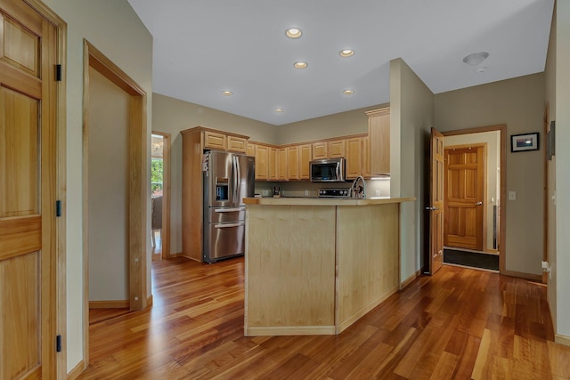 25845 12th St W, Zimmerman, MN 55398 - kitchen featuring stainless steel appliances, light brown cabinetry, wood finished floors, a peninsula, and light countertops