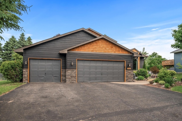 5641 146th Ave NW, Ramsey, MN 55303 - view of front facade featuring asphalt driveway, stone siding, and a garage