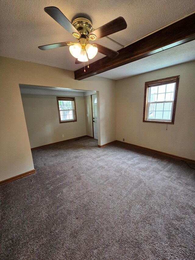 25 Morgan St, Tracy, MN 56175 - carpeted empty room featuring a ceiling fan, a textured ceiling, baseboards, and beamed ceiling
