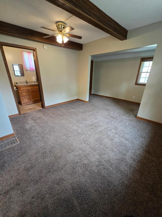 25 Morgan St, Tracy, MN 56175 - empty room with ceiling fan, beamed ceiling, baseboards, carpet flooring, and a smoke detector
