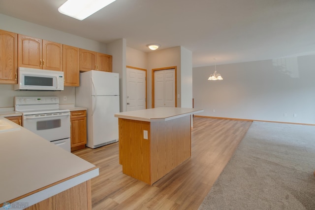 3401 28th St SW # 108, Fargo, ND 58104 - kitchen with white appliances, light wood-style floors, a chandelier, light countertops, and a kitchen island