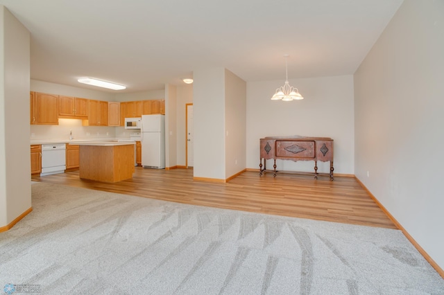 3401 28th St SW # 108, Fargo, ND 58104 - kitchen featuring white appliances, open floor plan, light carpet, light countertops, and baseboards