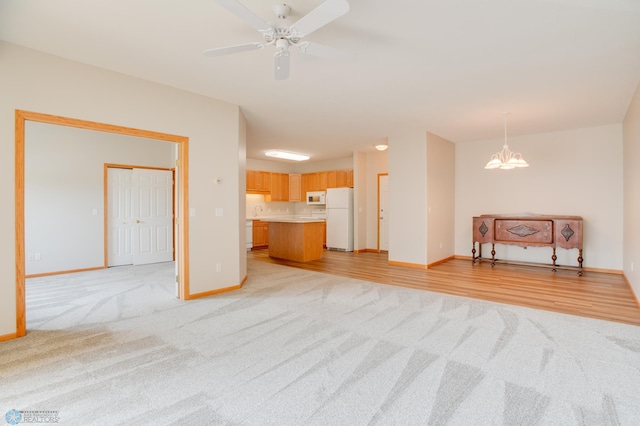3401 28th St SW # 108, Fargo, ND 58104 - unfurnished living room featuring light carpet, baseboards, a ceiling fan, a sink, and a chandelier