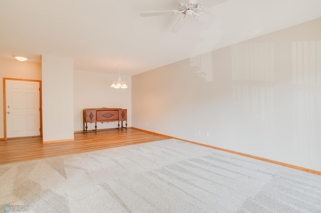 3401 28th St SW # 108, Fargo, ND 58104 - carpeted empty room featuring a chandelier, a ceiling fan, baseboards, and wood finished floors
