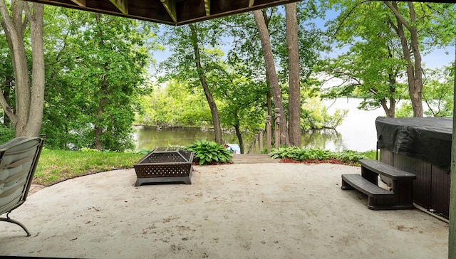 13100 Island View Dr NW, Elk River, MN 55330 - view of patio / terrace featuring a water view, a fire pit, a hot tub, and view of wooded area