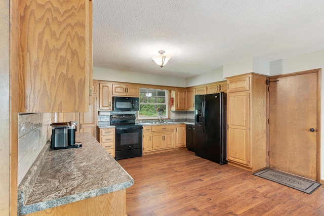 13100 Island View Dr NW, Elk River, MN 55330 - kitchen with black appliances, tasteful backsplash, a textured ceiling, light wood-style floors, and light brown cabinets