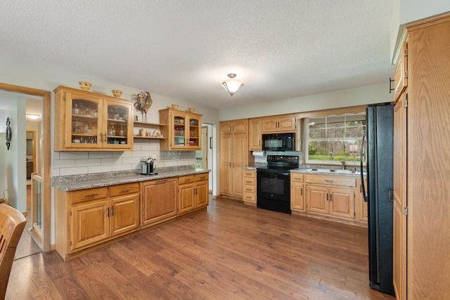 13100 Island View Dr NW, Elk River, MN 55330 - kitchen with black appliances, dark wood-style floors, a textured ceiling, backsplash, and glass insert cabinets