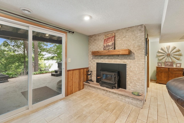 13100 Island View Dr NW, Elk River, MN 55330 - living room with a textured ceiling, wood finished floors, a wainscoted wall, wood walls, and a fireplace