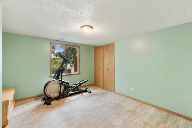 13100 Island View Dr NW, Elk River, MN 55330 - workout area with light wood-type flooring, a textured ceiling, and baseboards