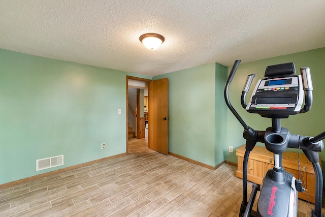 13100 Island View Dr NW, Elk River, MN 55330 - exercise area with wood finished floors, a textured ceiling, and baseboards