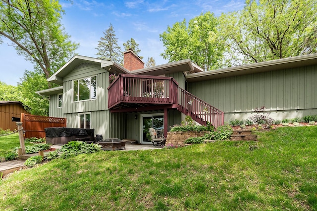 13100 Island View Dr NW, Elk River, MN 55330 - back of house with a chimney, a hot tub, a deck, stairs, and a yard
