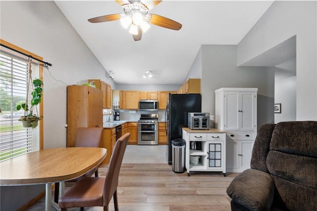 11509 Quay St, Coon Rapids, MN 55433 - kitchen featuring appliances with stainless steel finishes, open floor plan, lofted ceiling, light wood-style floors, and light countertops