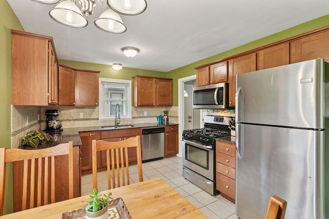 4124 14th Ave S, Minneapolis, MN 55407 - kitchen featuring appliances with stainless steel finishes, a sink, backsplash, brown cabinets, and light tile patterned floors