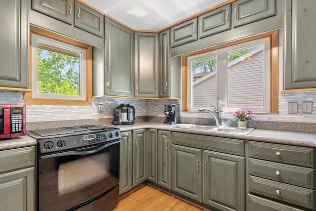 5554 Knoll Dr, Shoreview, MN 55126 - kitchen featuring black appliances, a sink, tasteful backsplash, light wood-style flooring, and green cabinets