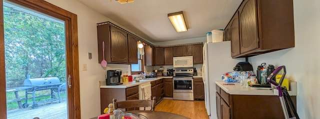 1422 6th St SE, Wadena, MN 56482 - kitchen with white appliances, light wood finished floors, light countertops, and a sink