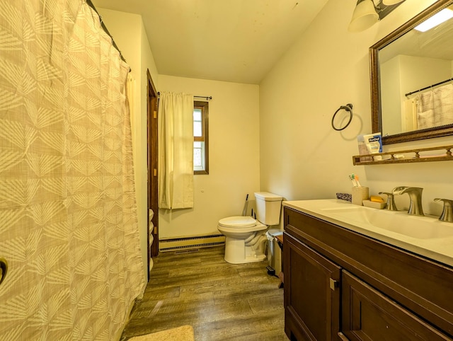 1422 6th St SE, Wadena, MN 56482 - bathroom featuring wood finished floors, toilet, baseboard heating, vanity, and vaulted ceiling