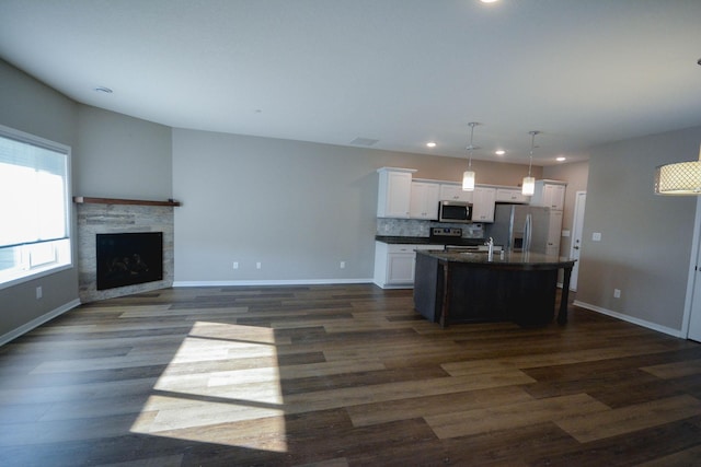 5656 Harvest Moon Blvd NW, Rochester, MN 55901 - kitchen featuring stainless steel appliances, a center island with sink, dark countertops, recessed lighting, and white cabinetry
