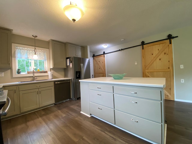 3771 County Line Rd, Moose Lake Twp, MN 55783 - kitchen with a barn door, appliances with stainless steel finishes, a sink, dark wood-type flooring, and a center island