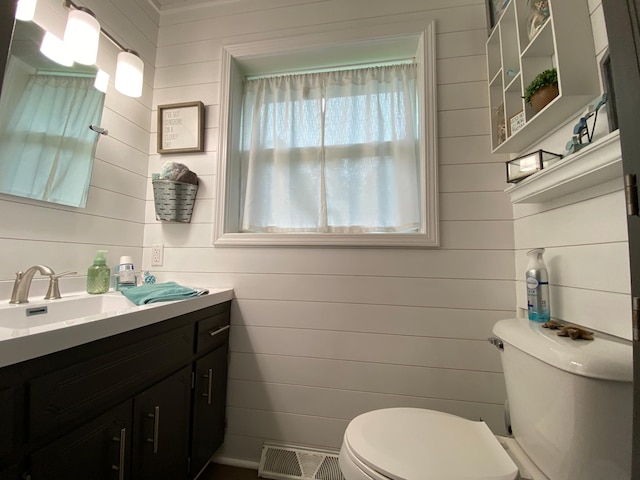 3771 County Line Rd, Moose Lake Twp, MN 55783 - half bathroom featuring toilet, vanity, and wooden walls