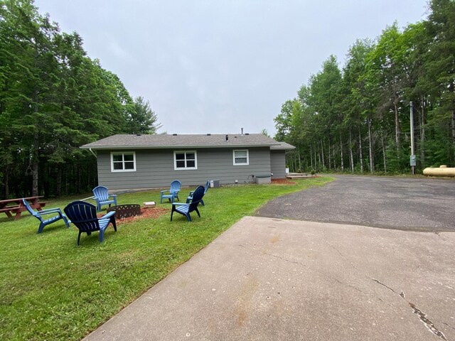 3771 County Line Rd, Moose Lake Twp, MN 55783 - rear view of property with an outdoor fire pit, a lawn, and driveway