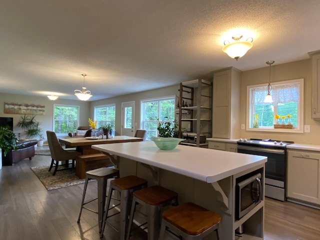 3771 County Line Rd, Moose Lake Twp, MN 55783 - kitchen with stainless steel appliances, light countertops, healthy amount of natural light, a kitchen island, and a textured ceiling
