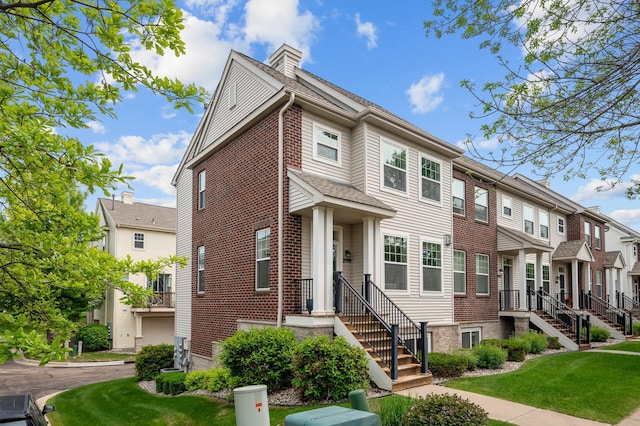 2099 Clover Ridge Dr, Chaska, MN 55318 - townhome / multi-family property featuring a residential view, a front lawn, and brick siding