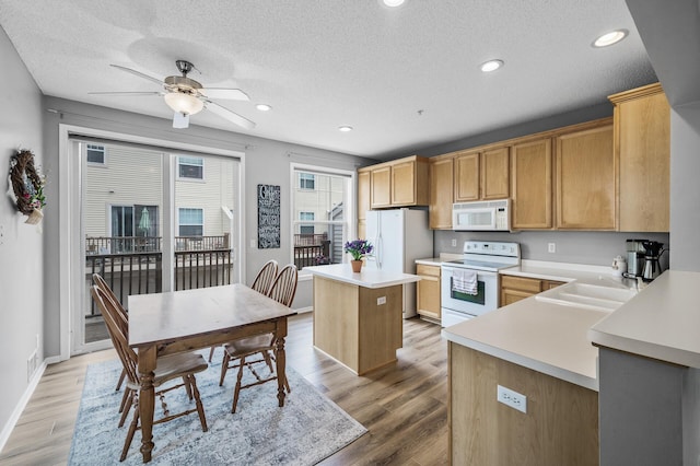 2099 Clover Ridge Dr, Chaska, MN 55318 - kitchen with white appliances, a kitchen island, a textured ceiling, ceiling fan, and light wood finished floors