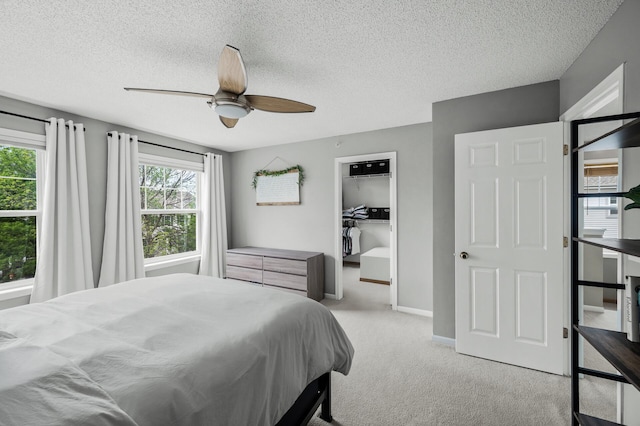 2099 Clover Ridge Dr, Chaska, MN 55318 - carpeted bedroom featuring a textured ceiling, a ceiling fan, a walk in closet, and baseboards