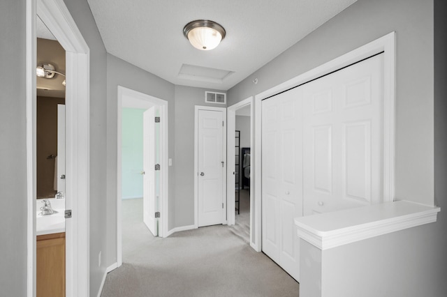 2099 Clover Ridge Dr, Chaska, MN 55318 - corridor featuring light colored carpet, baseboards, a sink, and attic access