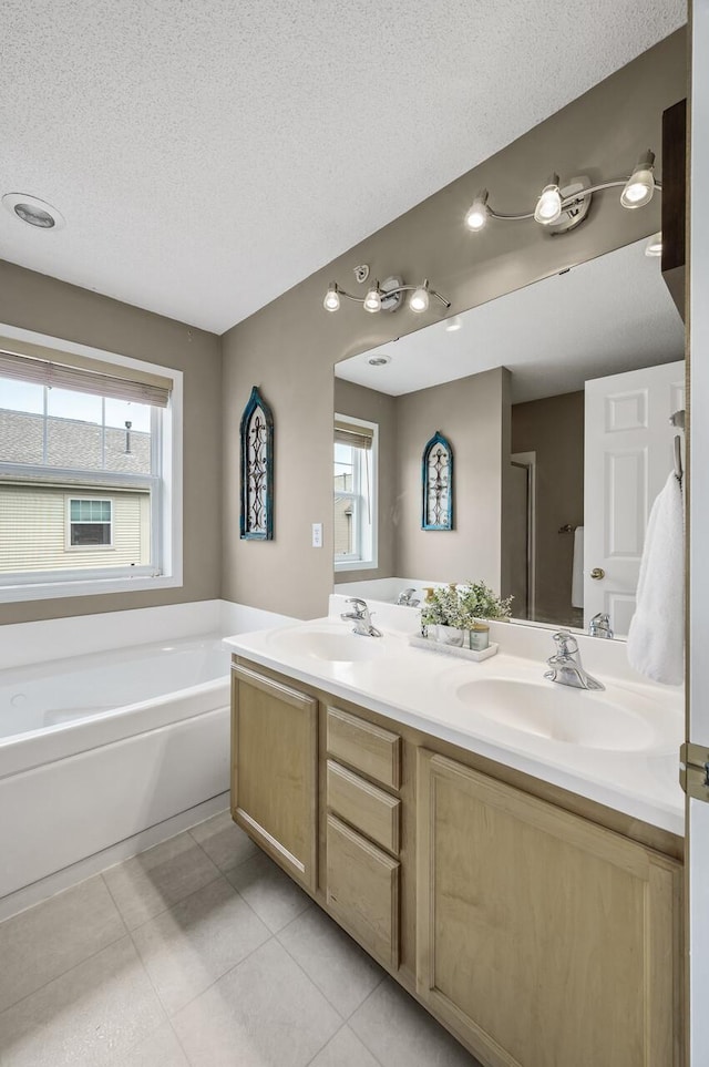 2099 Clover Ridge Dr, Chaska, MN 55318 - bathroom featuring double vanity, a bath, tile patterned floors, healthy amount of natural light, and a textured ceiling