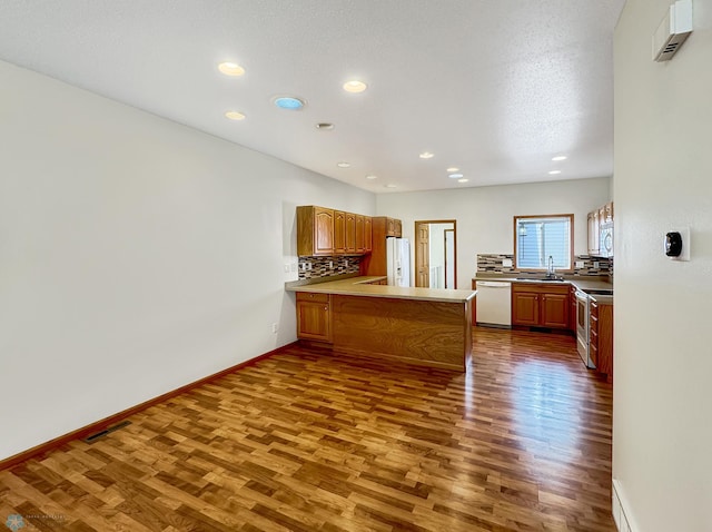 816 3rd St N Unit 816, Fargo, ND 58102 - kitchen featuring white appliances, dark wood-style flooring, a peninsula, recessed lighting, and decorative backsplash