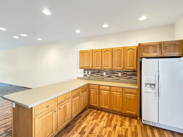 816 3rd St N Unit 816, Fargo, ND 58102 - kitchen with white fridge with ice dispenser, light countertops, light wood finished floors, decorative backsplash, and a peninsula