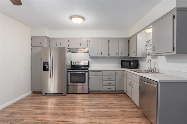 751 Sand Hill Pt, North Hudson, WI 54016 - kitchen featuring appliances with stainless steel finishes, ventilation hood, gray cabinetry, and a sink