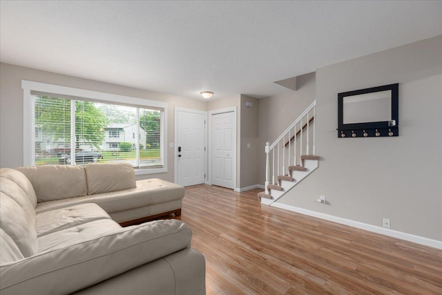 751 Sand Hill Pt, North Hudson, WI 54016 - living room featuring stairway, light wood-type flooring, and baseboards