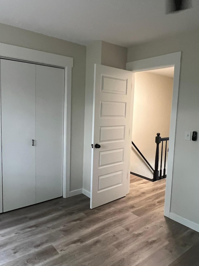 751 Sand Hill Pt, North Hudson, WI 54016 - unfurnished bedroom with wood finished floors, a closet, and baseboards