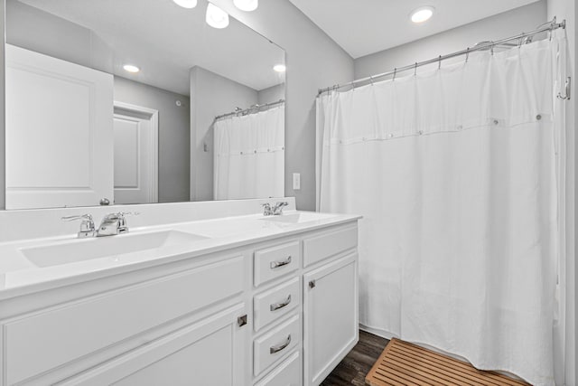 8756 Granite Ln, Woodbury, MN 55129 - bathroom with double vanity, wood finished floors, and recessed lighting