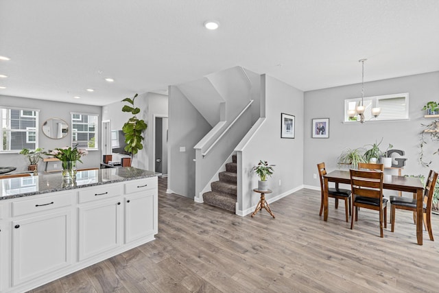 8756 Granite Ln, Woodbury, MN 55129 - dining space with light wood-style flooring, stairway, recessed lighting, a chandelier, and baseboards