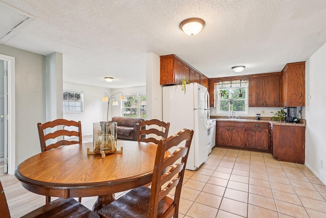 1524 Arlington Ave E, Saint Paul, MN 55106 - kitchen featuring freestanding refrigerator, plenty of natural light, a textured ceiling, light tile patterned floors, and light countertops