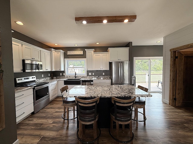 2771 271st Ave, Madison, MN 56256 - kitchen with stainless steel appliances, a sink, a breakfast bar, light stone counters, and recessed lighting