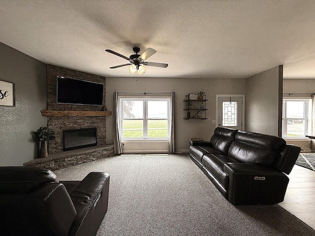 2771 271st Ave, Madison, MN 56256 - living area featuring ceiling fan, a textured ceiling, a fireplace, carpet flooring, and baseboards