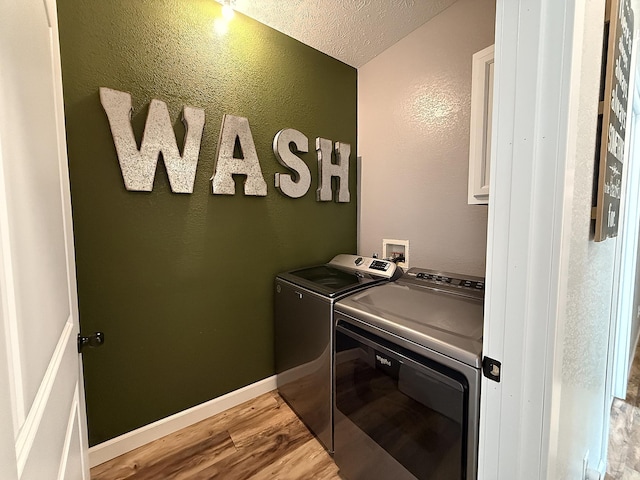 2771 271st Ave, Madison, MN 56256 - laundry area featuring washing machine and dryer, light wood-style floors, a textured wall, a textured ceiling, and baseboards